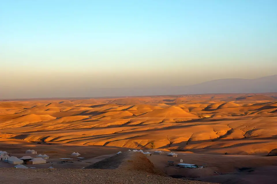Late light over rolling orange desert hills