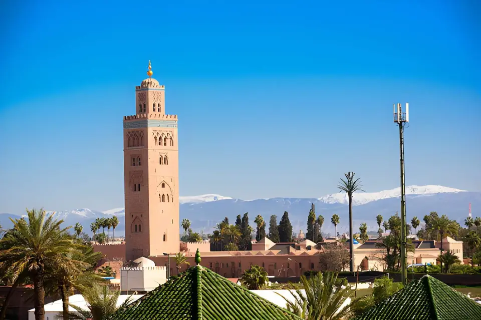 The Koutoubia minaret above the rooftops of Marrakech, with the Atlas behind